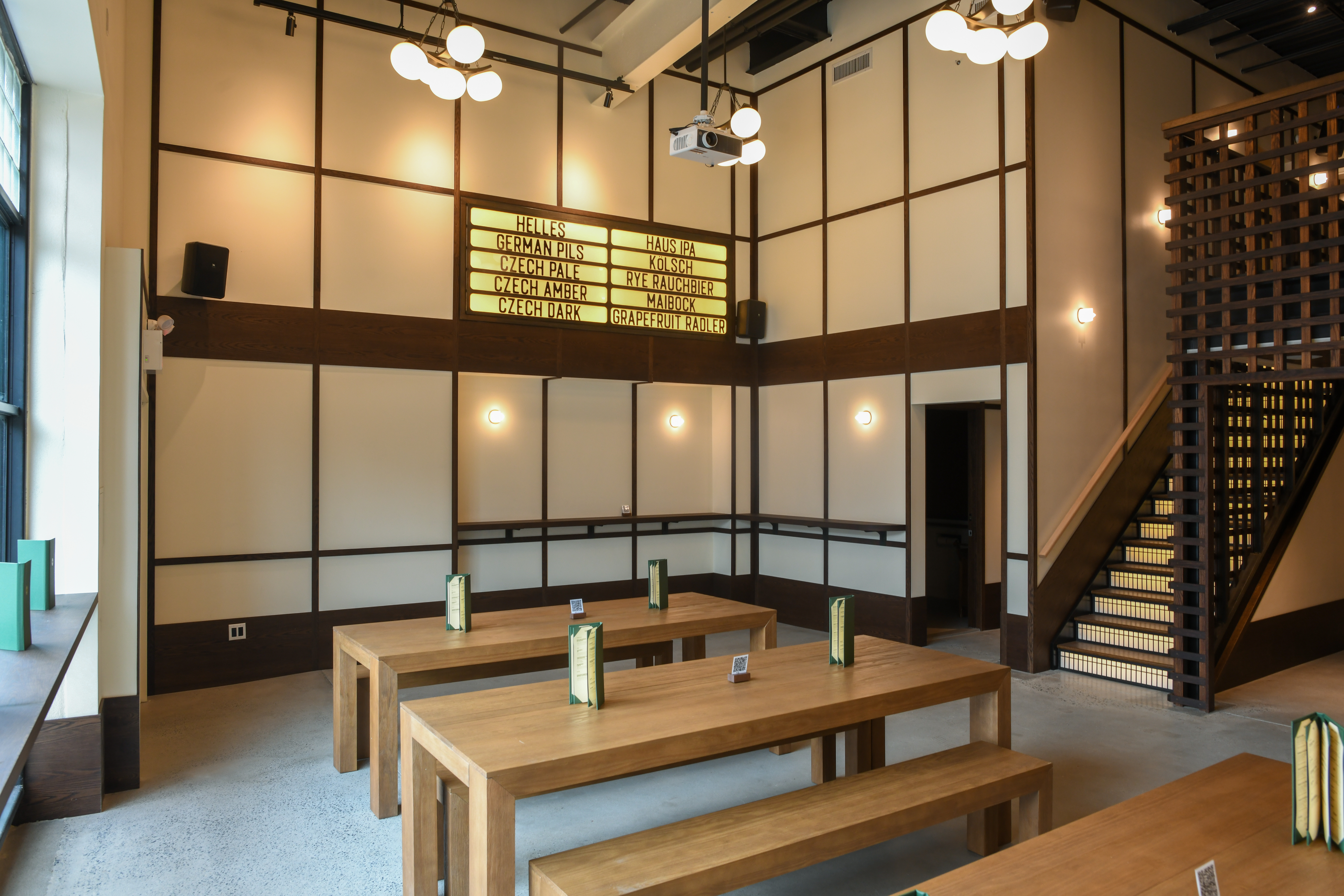 Eckhart Beer Co. taproom event space with communal tables and beer menu board